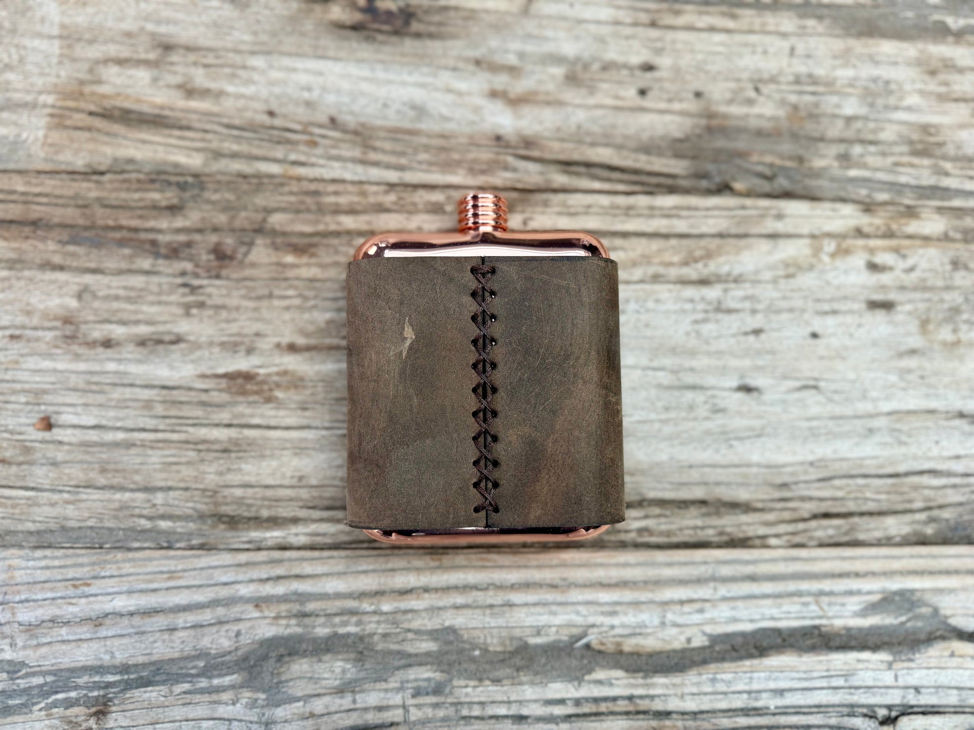 Leather wrapped copper colored stainless steel flask