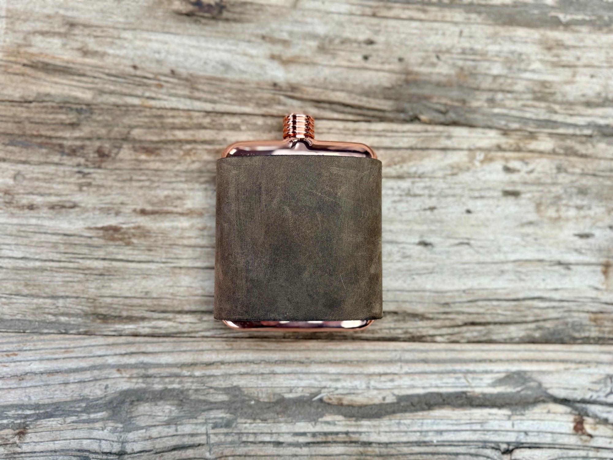 Leather wrapped copper colored stainless steel flask